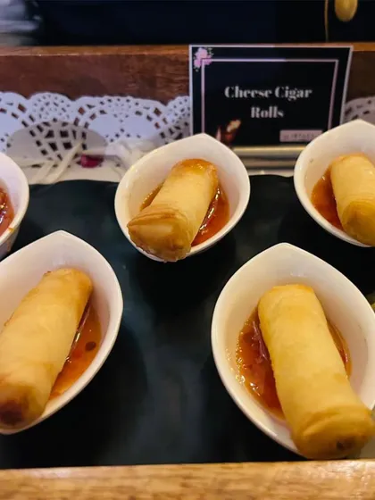 Cheese Cigar Rolls served in individual porcelain bowls with a sweet chili sauce. This is a clean and elegant way to serve a crispy, savory appetizer.