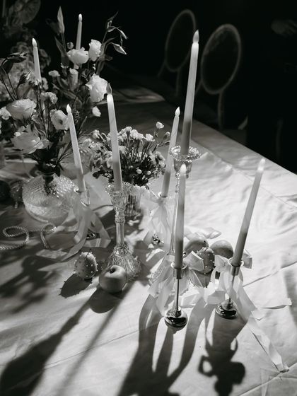 A black and white shot of the candlelit tablescape, highlighting the dramatic shadows and timeless elegance.