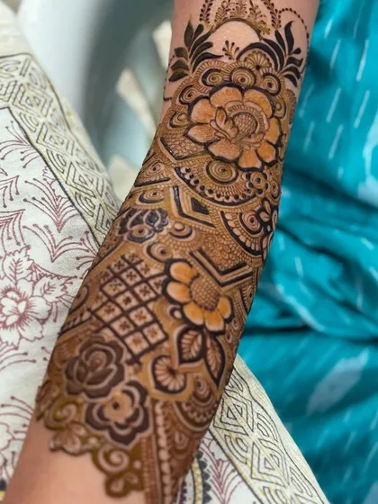 A close-up of the bold rose and floral motifs on the forearm. The shading gives the flowers a three-dimensional feel.