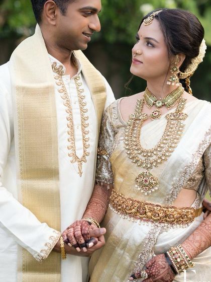 A beautiful couple shot, where the bride's henna-adorned hand is a central part of the loving moment.