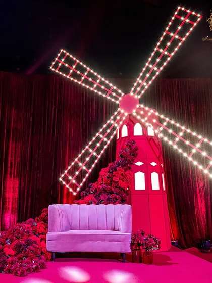 To add a touch of whimsical romance, I designed and built a custom red windmill with illuminated blades. It served as a unique photo backdrop, blending theatricality with the event's passionate theme.