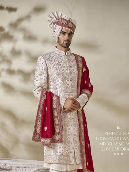 A classic ivory sherwani paired with a rich maroon stole. This look is perfect for the groom who wants to mix classic elegance with a contemporary pop of color, blending tradition with personal style.