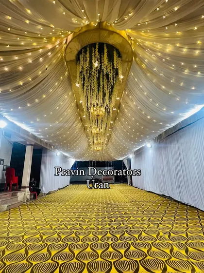 A stunning ceiling treatment we created for a long passageway. We used draped fabric with twinkling fairy lights and a central structure with hanging yellow flowers to create a magical atmosphere.