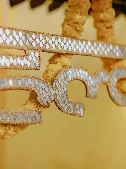 A detail shot of a decorative "Haldi" sign, capturing the small, personalized elements of the event decor.