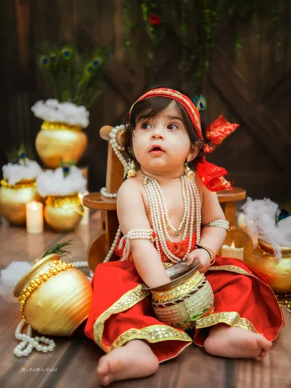 A curious look from our little Krishna. The details of the setup, from the matkis to the candles, create a beautiful ambiance.