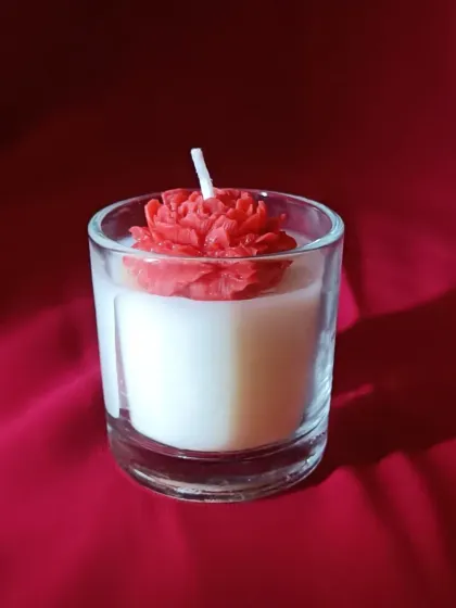 This is our elegant rose fragrance shot glass candle. It combines a creamy soy wax base with a detailed, handcrafted rose on top, making it a perfect little gift or a beautiful accent for a romantic evening.