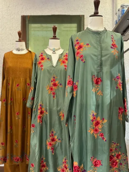 A display of floral embroidered kurtas in earthy tones of sage green and mustard. These pieces are perfect for adding a touch of nature-inspired beauty to your wardrobe.