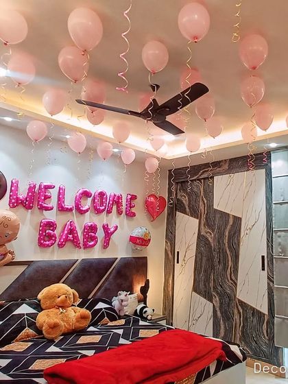 A wider view of the bedroom welcome decor, showing how the decorations are arranged to make the entire room feel special without being overwhelming. The teddy bear on the bed adds a cute touch.