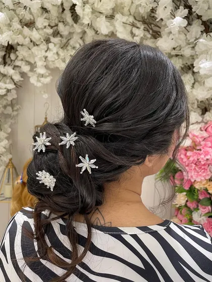 A classic Western-style low bun with sparkling star accessories. This elegant and textured bun is perfect for a reception gown or a Christian wedding.