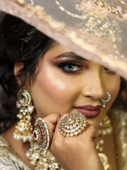 Mastering the art of the classic bridal look. This is a demonstration of a flawless, soft-glam bridal makeup, focusing on a radiant base, subtle smokey eyes, and elegant jewelry placement, a core skill in our curriculum.