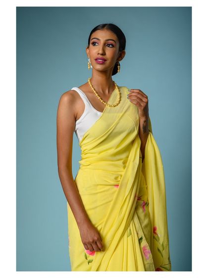 A three-quarter shot of the yellow saree, focusing on the upper body and the way the fabric falls.