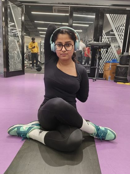 A member practices Gomukhasana (Cow Face Pose) arms, a great stretch for opening up the shoulders and chest.