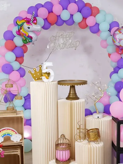 A close-up of the unicorn theme setup, showing the different colored balloons and props like the mini Ferris wheel and birdcage.