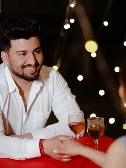 A close-up of the couple sharing a toast. The warm, soft light from the fairy lights creates a flattering and romantic glow, perfect for capturing these special moments.
