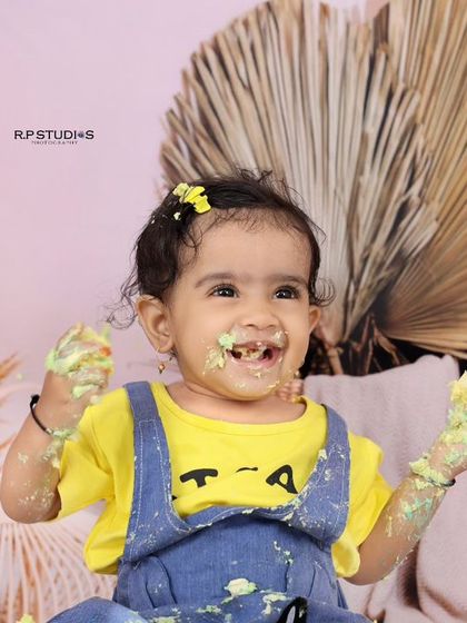 The best part of a cake smash is getting messy! This little girl's joyful, frosting-covered face is a perfect example of the fun we have during these sessions.