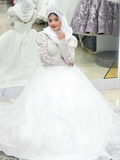 A bride seated in her magnificent ball gown, the skirt pooling around her. The mirror reflection shows just how much detail and craftsmanship went into this creation.