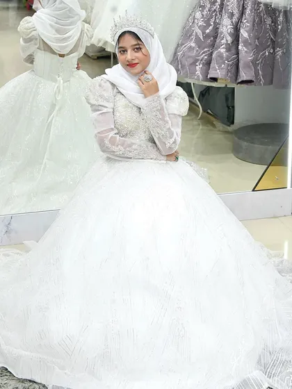 A bride seated in her magnificent ball gown, the skirt pooling around her. The mirror reflection shows just how much detail and craftsmanship went into this creation.