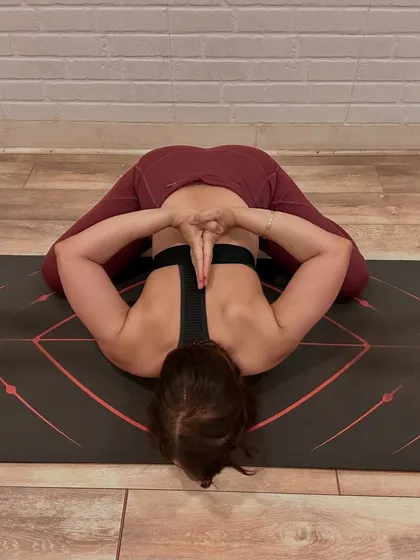 A seated forward fold with hands in Anjali Mudra behind the back. This pose, a variation of Baddha Konasana, is a deep hip opener and a moment to pause, breathe, and realign.