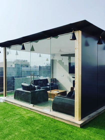 A daytime view highlighting the sleek design of our glass room. The black ACP paneling combined with floor-to-ceiling glass offers a modern, minimalist aesthetic that complements any urban environment.