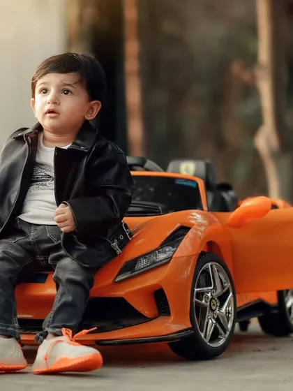 A cool and casual pose from a little car enthusiast. The natural outdoor lighting and his relaxed attitude make this a great portrait.