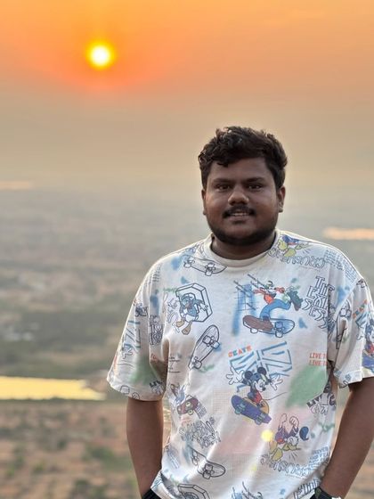 A happy trekker with the beautiful sunrise behind him. The golden hour light is perfect for photos.