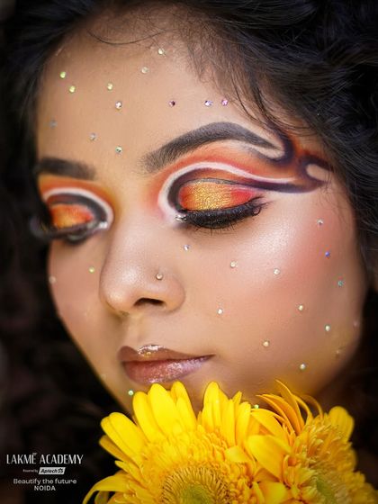 A sunflower-themed eye makeup look. The warm yellow and orange tones, combined with a graphic liner, create a look that is both artistic and beautiful.