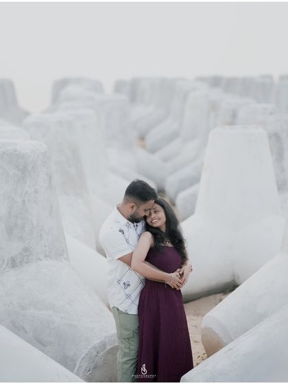 A comforting hug amidst the striking white tetrapods. This setting provides a unique and artistic backdrop for an engagement session.