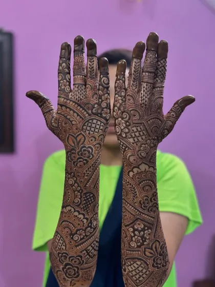 A gorgeous engagement mehendi with peacock and floral motifs. The design is intricate and covers the arms beautifully.