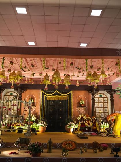 This image shows the grand scale of the naming ceremony stage. The high ceiling is adorned with hanging decorations, drawing the eye upwards and adding to the festive, celebratory feel of the event.