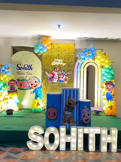 Another take on the popular Cocomelon theme, this setup features multiple arches and a gold shimmer wall. The stage is decorated with character cutouts, themed plinths, and large, light-up letters spelling the birthday boy's name.