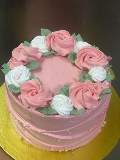 A simple and pretty pink cake with a wreath of buttercream roses.