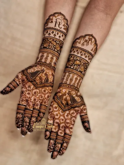 A traditional design with a personal touch. This beautiful mehendi features classic peacock and elephant motifs, along with the couple's initials elegantly placed on the forearm.