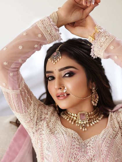 A confident and glamorous portrait of the bride, showcasing her stunning makeup and intricate outfit.