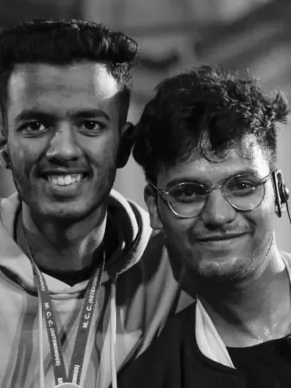 A black and white portrait of two friends at a college fest, capturing the bond and shared experience.
