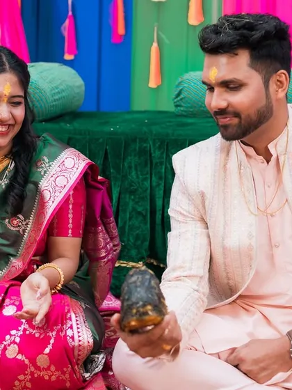 A playful moment during a pre-wedding ceremony. The couple's smiles show the fun and lightheartedness of the event.