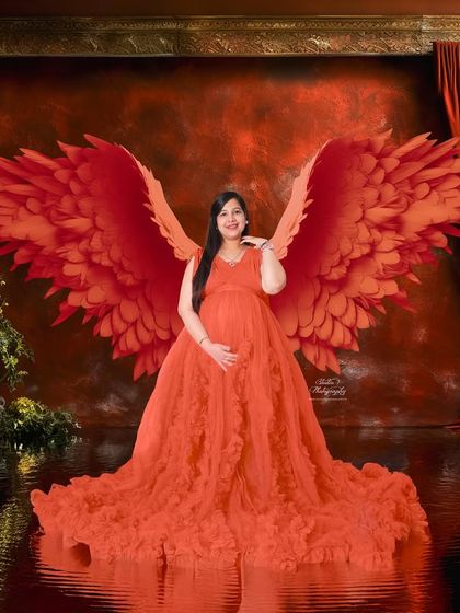 A joyful portrait with the red angel wings. The expecting mother's happy expression shows how much fun these creative studio sessions can be.