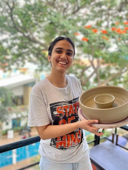 A proud student holding her first large chip-and-dip bowl. Moments like these are what make teaching so rewarding.