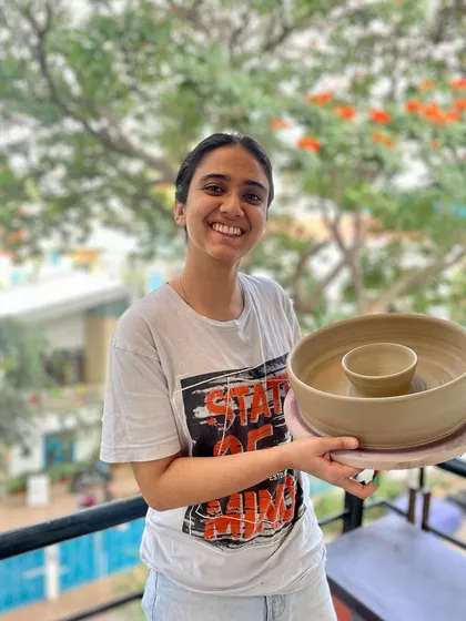 A student proudly holding her chip-and-dip bowl, one of the many pieces she created during her course.