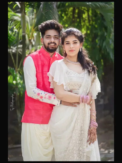 A bright and happy portrait of a couple in beautiful, coordinated traditional outfits. Their comfortable pose and direct look at the camera make for a lovely and classic pre-wedding photo.