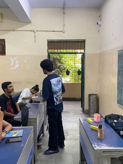 Our Kalakaar fellows lead a songwriting workshop in a school, using a blackboard to brainstorm ideas with students. This shows the academic and creative process behind our music.