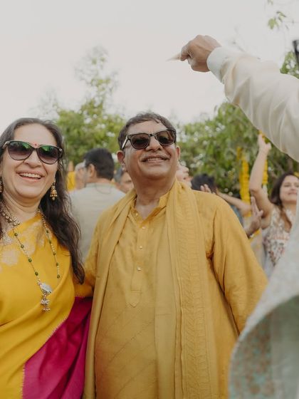 The parents enjoying the outdoor festivities, dressed in cheerful yellow ensembles. Their relaxed smiles show that comfort is just as important as style, a principle we always follow.