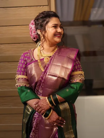 A lovely candid of the bride, showcasing the detailed embroidery on her blouse sleeves and the beautiful texture of her silk saree.