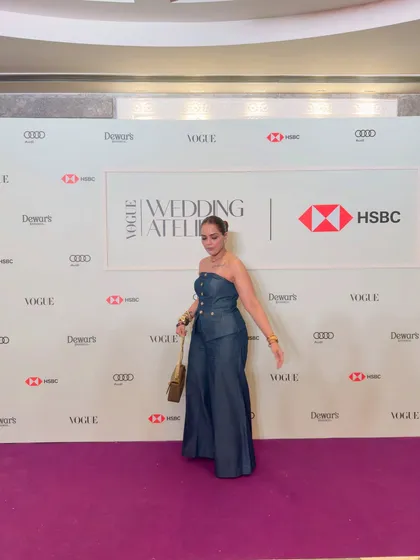A candid moment from the Vogue event. The wide-leg denim jumpsuit allows for easy movement while maintaining a chic, put-together appearance.