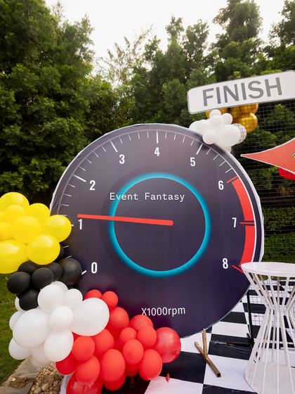 A giant speedometer prop, a key element of the Ferrari racing theme, showing the needle revving up for fun.