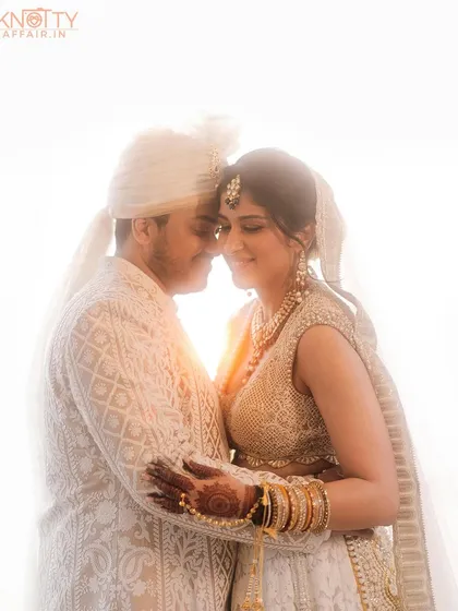 A beautiful backlit portrait of the couple, their faces close together against a bright, glowing light. This image from their Mumbai wedding has a dreamy, ethereal quality that focuses purely on their connection.