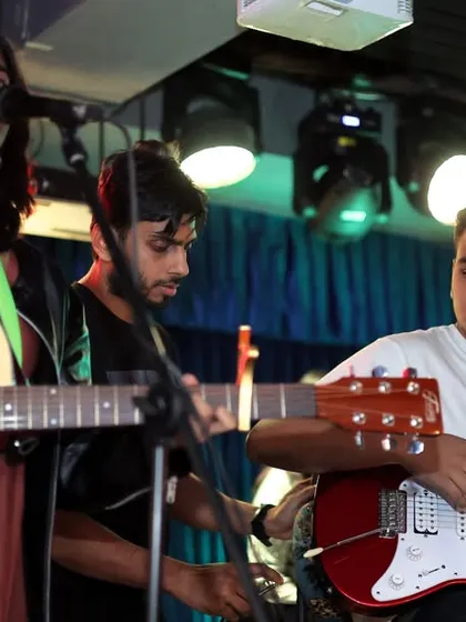The energy of a full band playing in sync is unbeatable. Here's one of our student bands during our annual showcase, with students on acoustic and electric guitar working together. Our coaching focuses on this kind of group dynamic and performance energy.