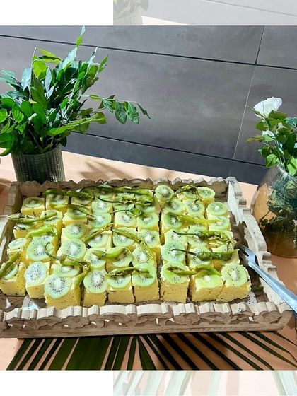 A tray of delicate, bite sized kiwi pastries. These light and fruity desserts are a refreshing option for any event, from a corporate lunch to a high tea.
