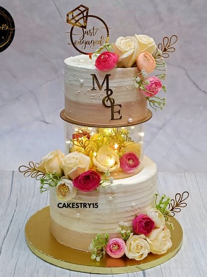A stunning 3kg choco-vanilla engagement cake with a glowing light-up spacer. The tiers are decorated with artificial roses and carnations for a timeless and romantic look.