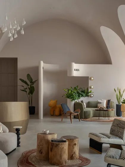 This angle highlights the contrast between the smooth, plastered vaults and the textured, natural materials of the furniture and rugs.