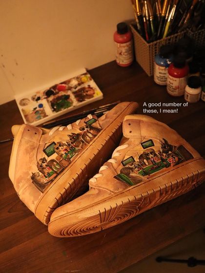 This is a detailed shot of the "Dogs Playing Poker" design on the coffee-dyed Air Jordan 1s. You can see the rich, layered colors and the aged effect the coffee provides to the entire sneaker.